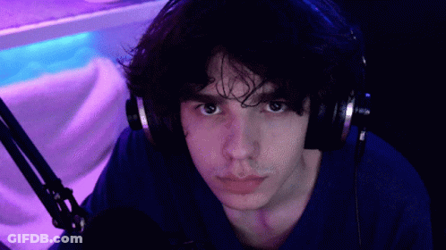 Man In Headphones And Blue Shirt Pointing At Camera GIF