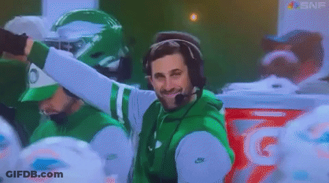 Man In Headphones And Green Jacket In Front Of Gatorade Cooler GIF