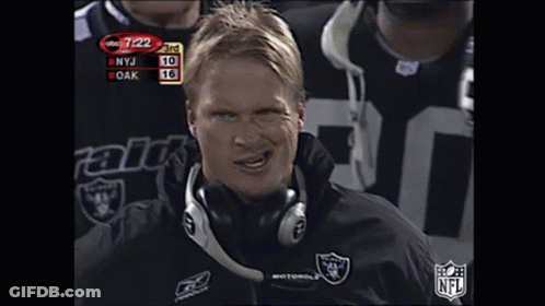Man In Headphones And Raiders Jacket Looking At Camera GIF