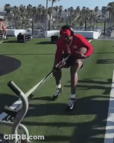 Man In Headphones And Red Nike Hat Holding Hockey Stick GIF