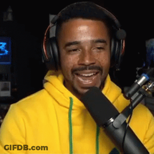 Man In Headphones And Yellow Hoodie Talking Into Microphone GIF