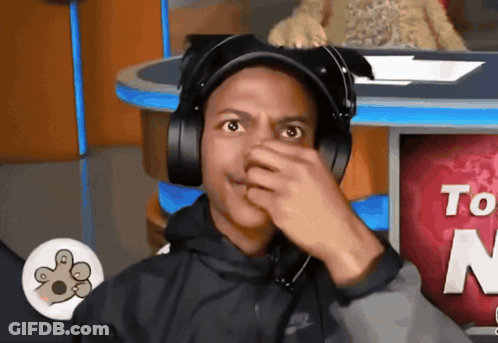 Man In Headphones Covering Nose In Front Of Sign Saying To GIF