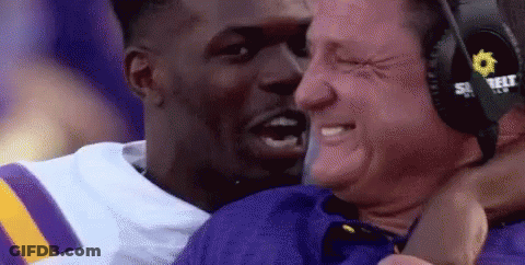 Man In Headphones Hugging Football Player In Purple And Yellow Jersey GIF