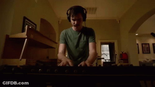 Man In Headphones Playing Keyboard In Living Room GIF