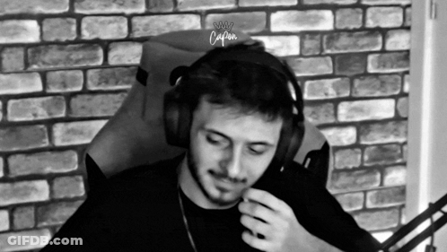 Man In Headphones Sitting In Chair In Front Of Brick Wall GIF