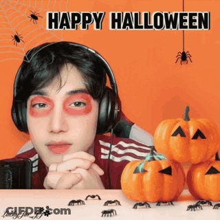 Man In Headphones Surrounded By Pumpkins And Spiders Saying Happy Halloween GIF