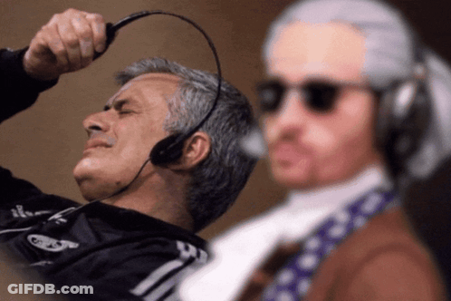 Man In Headset Looks At Man In Wig GIF