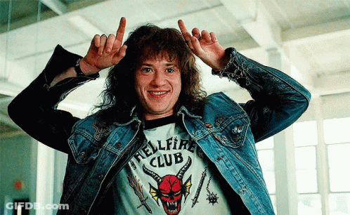 Man In Hellfire Club Shirt Making Horn Sign GIF