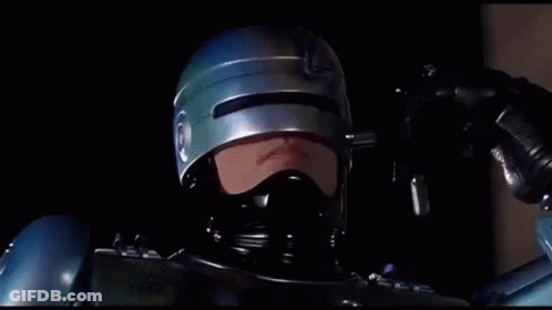 Man In Helmet And Mask Holding Gun Says We're Only Human GIF