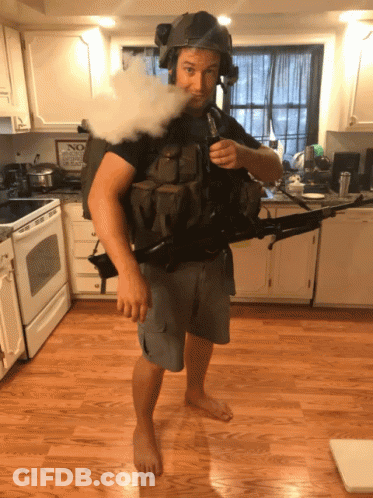 Man In Helmet Holding Gun Smoking Cigarette GIF