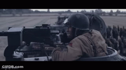 Man In Helmet Holding Machine Gun In Tank GIF
