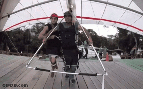 Man In Helmet Number 5 Pulled By Another Man GIF