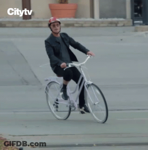 Man In Helmet Riding Bike With Citytv Logo GIF