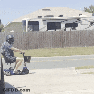 Man In Helmet Riding Mobility Scooter GIF