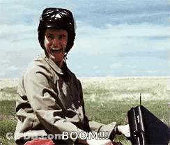 Man In Helmet Sitting In Field Holding Briefcase Laughing GIF