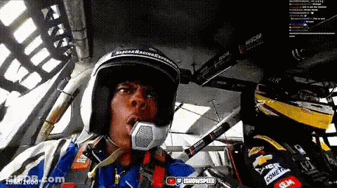 Man In Helmet Sitting In Race Car Talking Into Microphone GIF