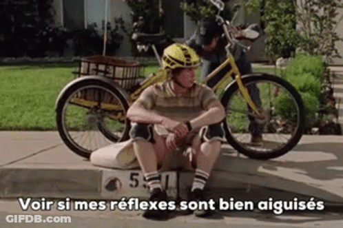 Man In Helmet Sitting On Curb Next To Bicycle Saying Voir GIF