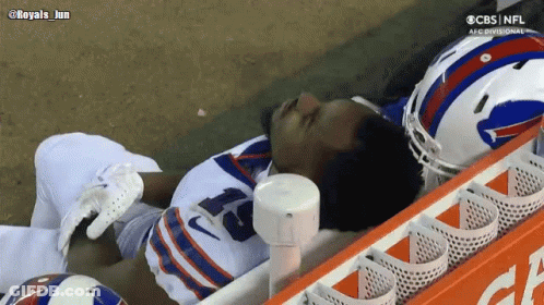 Man In Helmet Talks To Another Man Watching CBS Football GIF