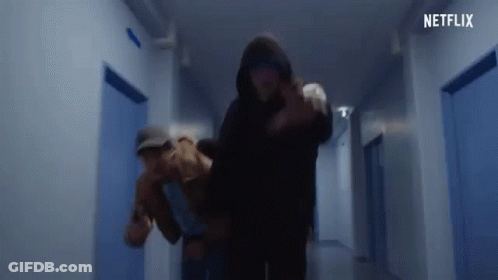 Man In Hooded Jacket Carrying Woman In Hallway GIF