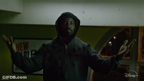 Man In Hooded Jacket In Front Of New York Sign GIF
