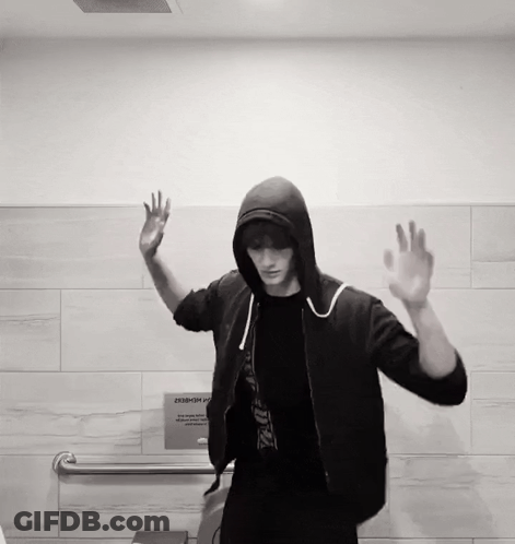 Man In Hooded Jacket In Front Of Sign Saying A Member GIF