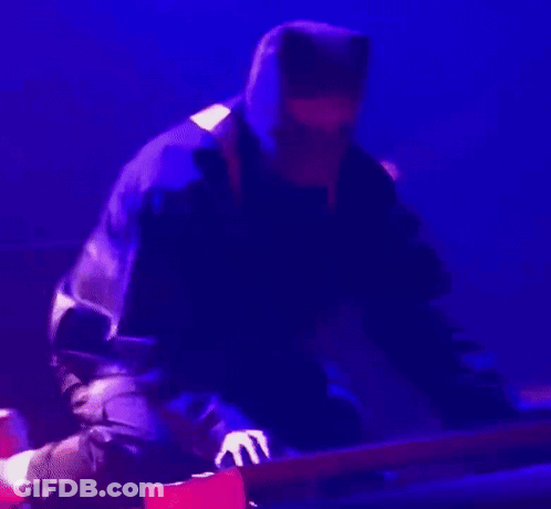 Man In Hooded Jacket Playing Guitar On Stage GIF