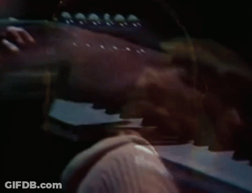Man In Hooded Jacket Playing Guitar On Stage GIF