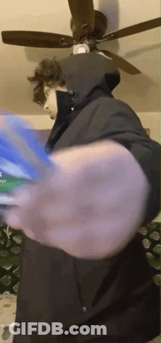 Man In Hooded Jacket Playing Video Game With Ceiling Fan GIF