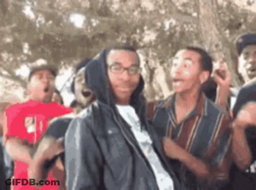 Man In Hooded Jacket Surrounded By Crowd GIF