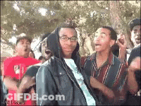 Man In Hooded Jacket Surrounded By Crowd GIF
