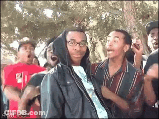 Man In Hooded Jacket Surrounded By Crowd GIF