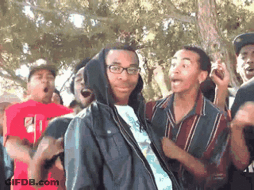 Man In Hooded Jacket Surrounded By Group GIF