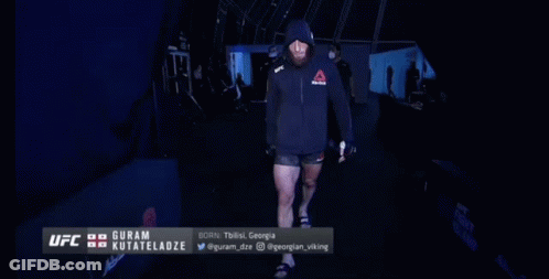 Man In Hooded Jacket Walking Into UFC Room GIF
