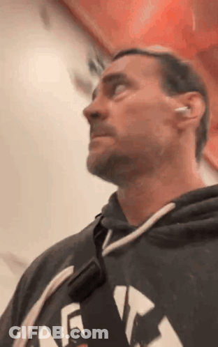 Man In Hoodie And Earbuds Looking Up GIF
