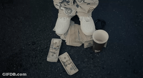 Man In Hoodie Holding Water Bottle In Front Of Motel GIF