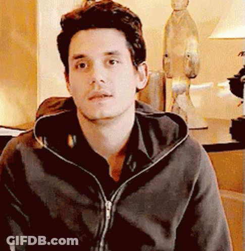 Man In Hoodie Looking At Camera With Statue GIF