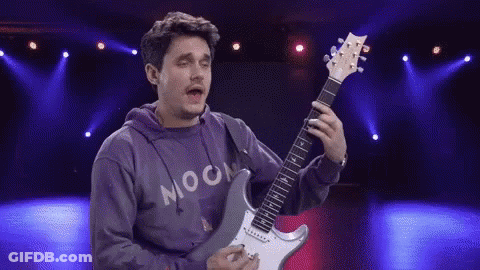 Man In Hoodie Playing Electric Guitar On Stage GIF