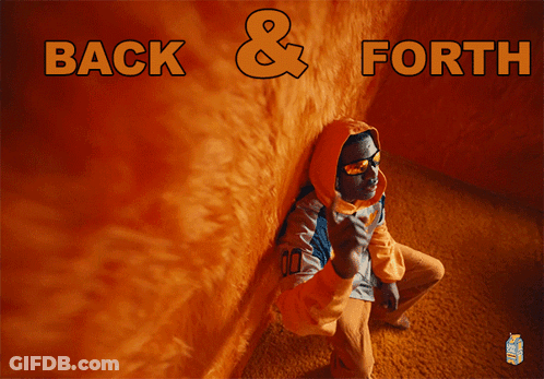Man In Hoodie Sitting By Orange Wall GIF