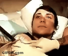 Man In Hospital Bed With Head Bandage And Gloves GIF