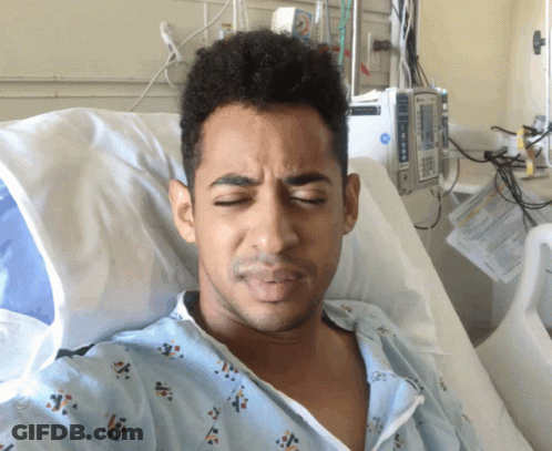 Man In Hospital Gown Lying In Bed Next To Medical Device GIF