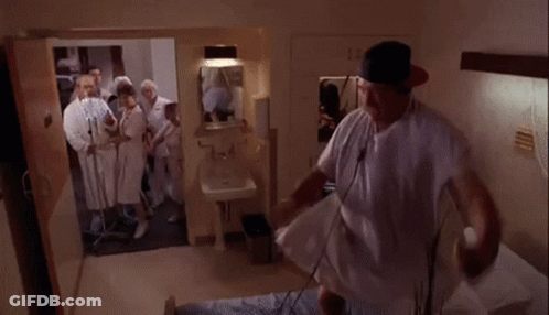 Man In Hospital Gown Surrounded By Doctors GIF