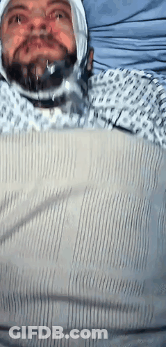 Man In Hospital Gown With Bandage On Head GIF