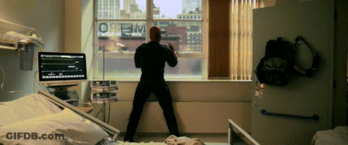 Man In Hospital Room Looking Out Window With Optimum GIF
