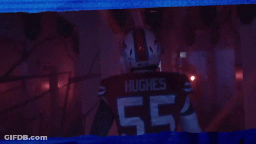 Man In Hughes Jersey Standing In Dark Room GIF
