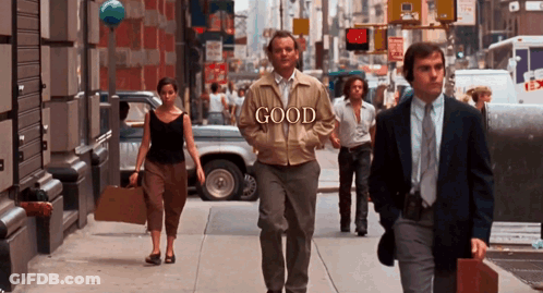 Man In Jacket Saying Good Walking Down Street GIF