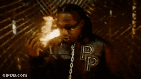 Man In Jacket With Letter P Standing In Front Of Fire GIF