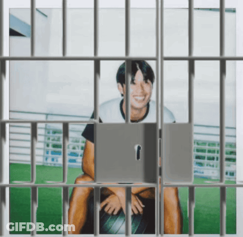 Man In Jail Cell Behind Bars GIF