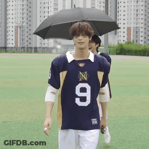 Man In Jersey Number 9 Holding Umbrella GIF