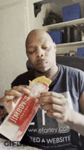 Man In Jimboy's Shirt Eating Sandwich GIF