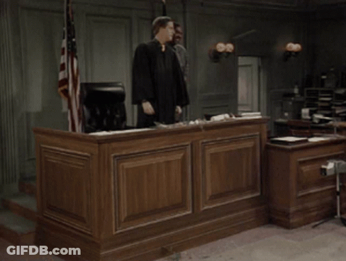 Man In Judge Robe Holding Gavel In Courtroom GIF